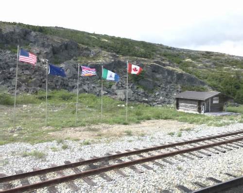 Skagway Train Trip NWMP Alaska BC Border with Flags